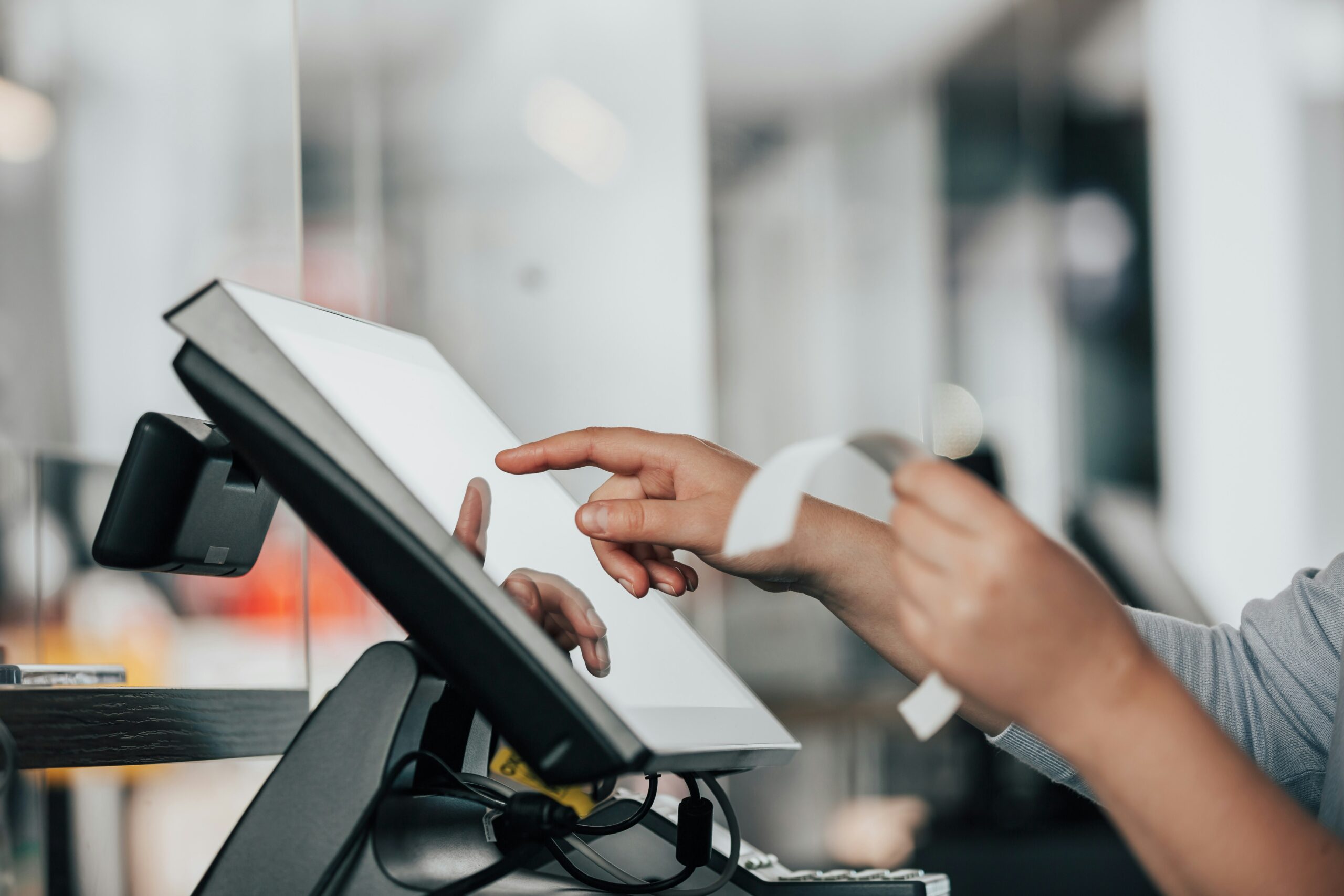 Person using POS machine and holding a paper receipt