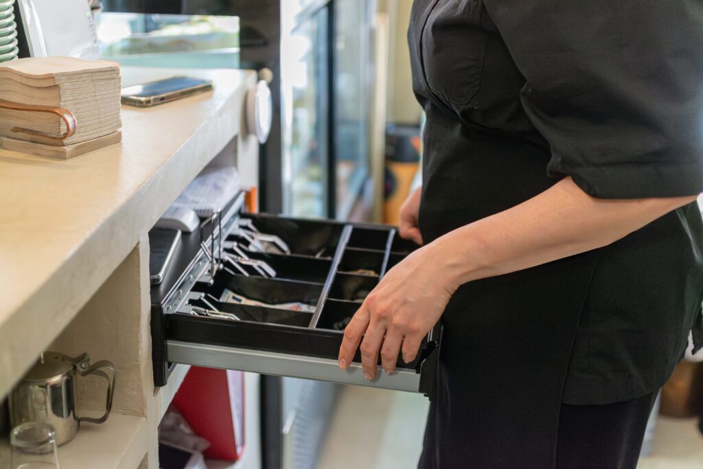 Restaurant worker opening cash register drawer